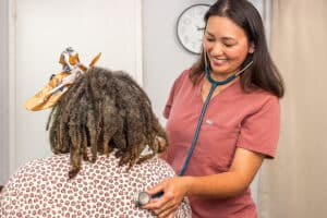 A nurse checking a woman's heart beat at Medical Hill