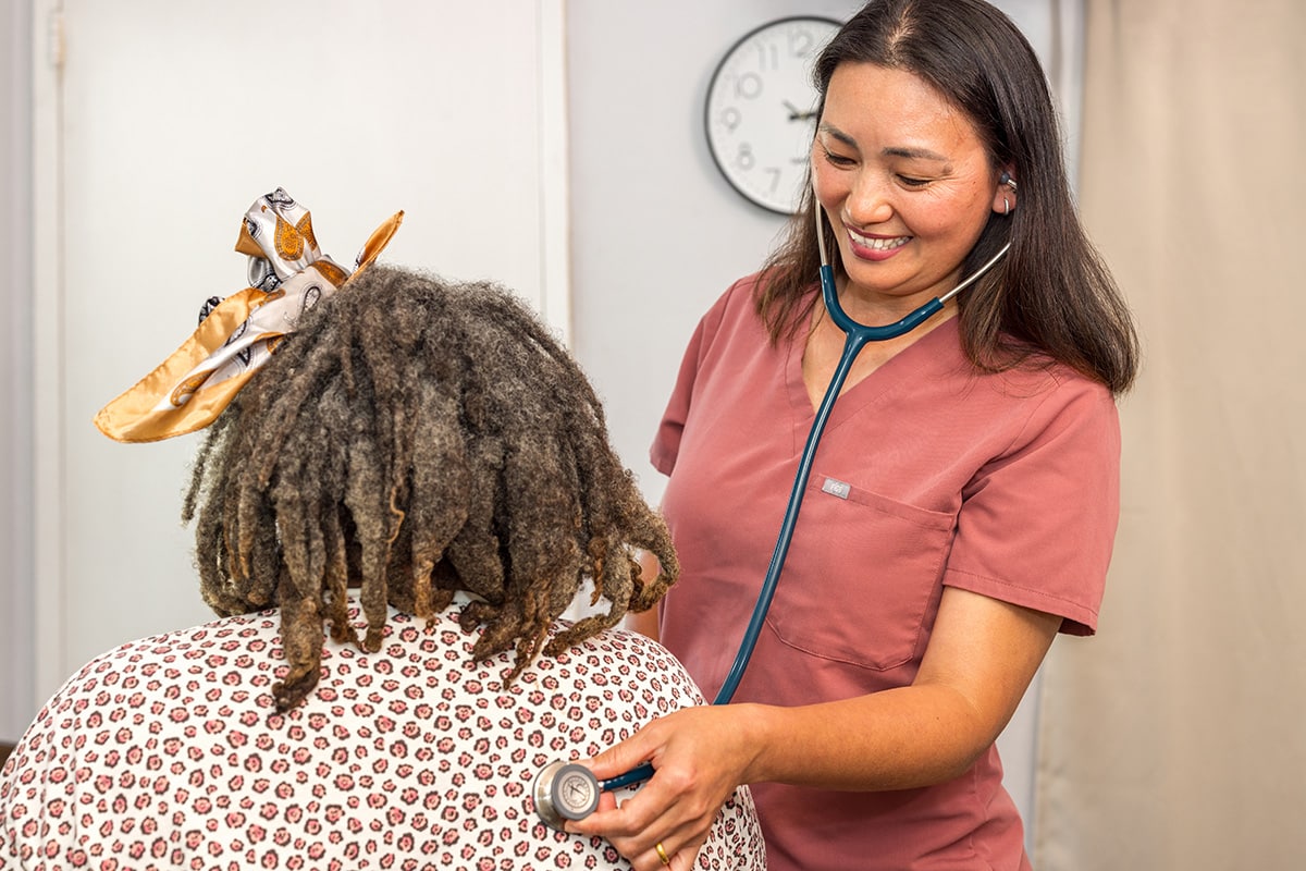 A nurse checking a woman's heart beat at Medical Hill