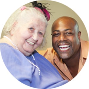 A man laughing with an elderly woman