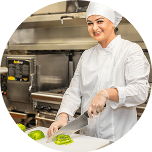A chef cutting up peppers in the kitchen